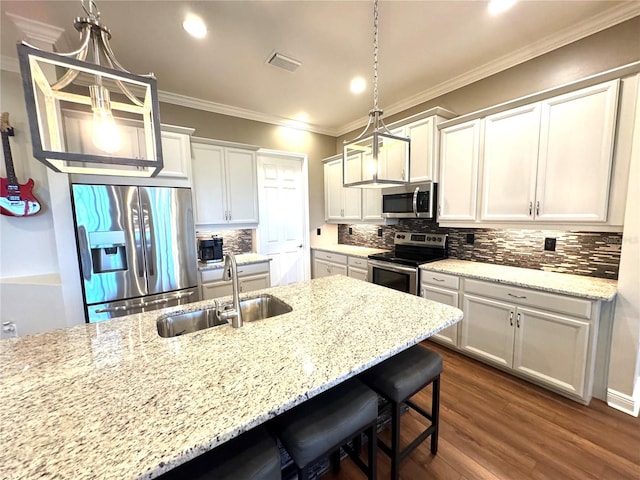 kitchen with pendant lighting, white cabinetry, sink, and appliances with stainless steel finishes