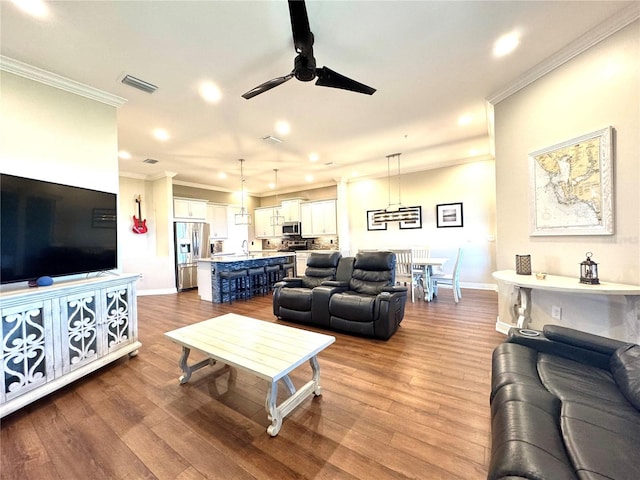 living room with ceiling fan, light hardwood / wood-style flooring, crown molding, and sink