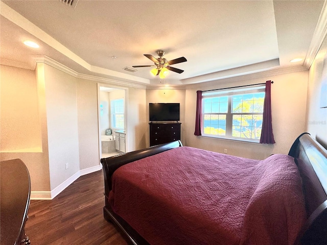 bedroom with ceiling fan, dark hardwood / wood-style flooring, a raised ceiling, and ensuite bathroom