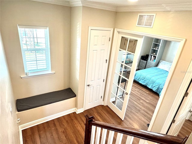 entryway with crown molding and wood-type flooring