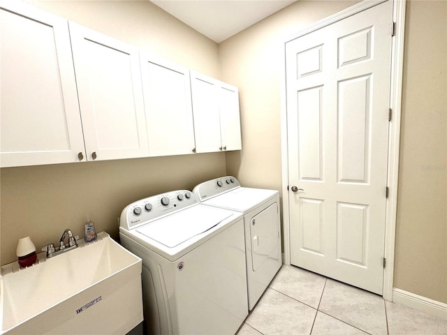 laundry area featuring cabinets, light tile patterned floors, washer and dryer, and sink