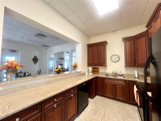 kitchen featuring kitchen peninsula, a drop ceiling, sink, black appliances, and light tile patterned flooring