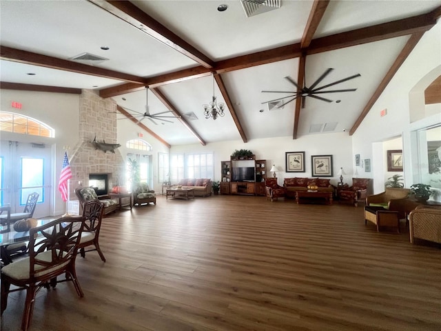 living room featuring dark wood-type flooring, an inviting chandelier, high vaulted ceiling, beamed ceiling, and a fireplace