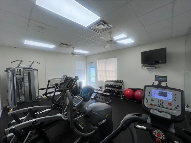 gym with a paneled ceiling and ceiling fan