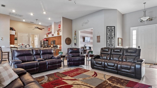 tiled living room with ceiling fan and a towering ceiling