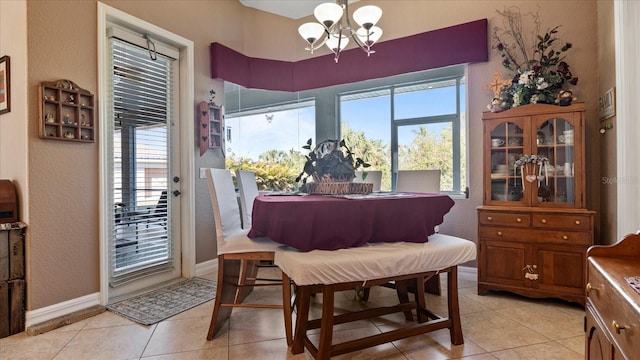 dining space featuring light tile patterned floors and an inviting chandelier