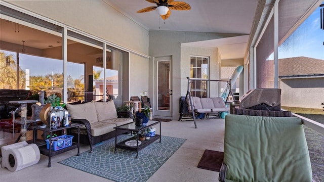 sunroom / solarium with ceiling fan, vaulted ceiling, and plenty of natural light