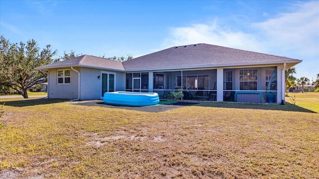 back of property featuring a sunroom and a yard