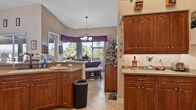 kitchen with decorative light fixtures, an inviting chandelier, sink, kitchen peninsula, and light tile patterned flooring