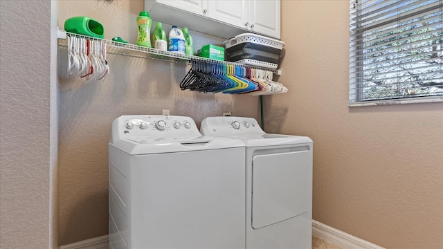 laundry room featuring washer and dryer and cabinets