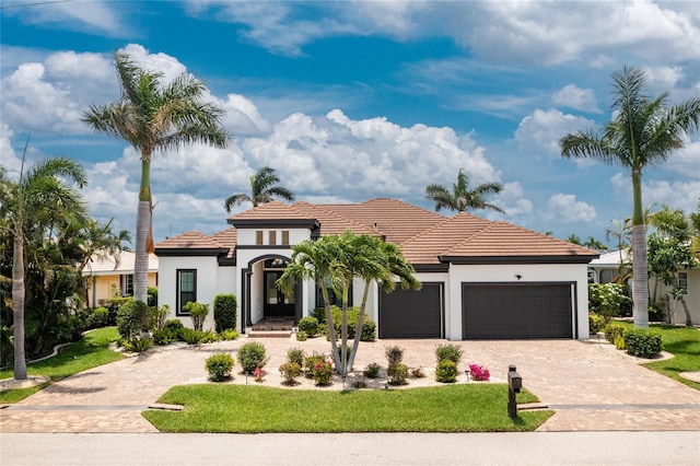 mediterranean / spanish house featuring a front yard and a garage