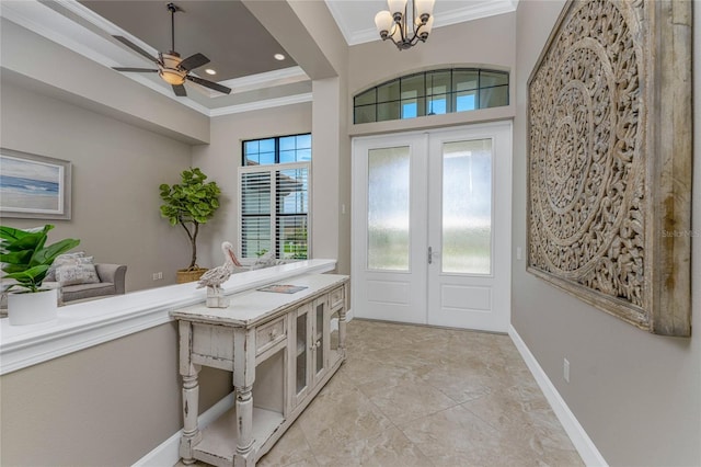 entryway featuring a healthy amount of sunlight, french doors, ceiling fan with notable chandelier, and crown molding