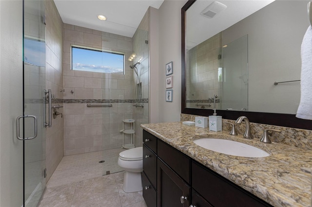 bathroom with tile patterned floors, toilet, vanity, and an enclosed shower