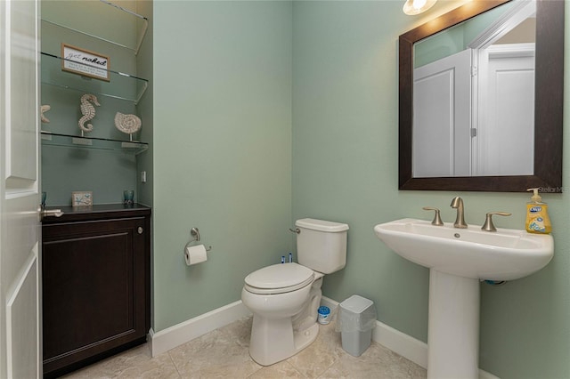 bathroom with sink, toilet, and tile patterned flooring