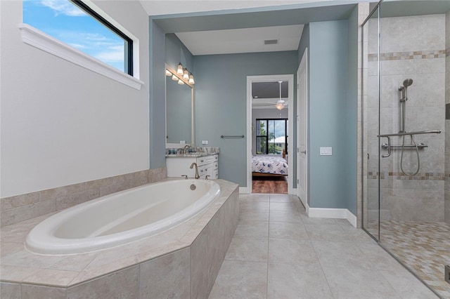 bathroom with independent shower and bath, a wealth of natural light, and vanity