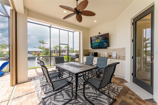 sunroom / solarium featuring ceiling fan