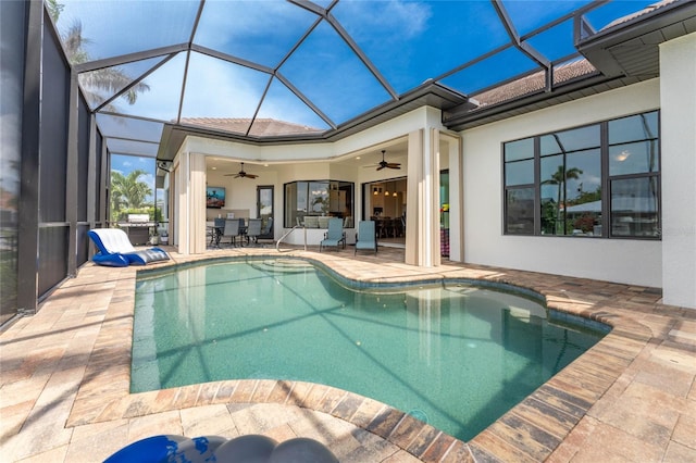 view of swimming pool featuring ceiling fan, a lanai, and a patio area