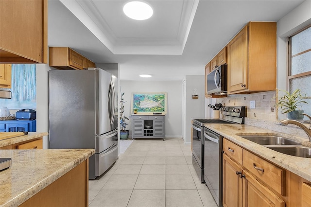 kitchen featuring a raised ceiling, sink, light stone countertops, light tile patterned floors, and stainless steel appliances