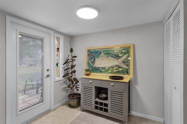 doorway to outside with light tile patterned floors and a healthy amount of sunlight