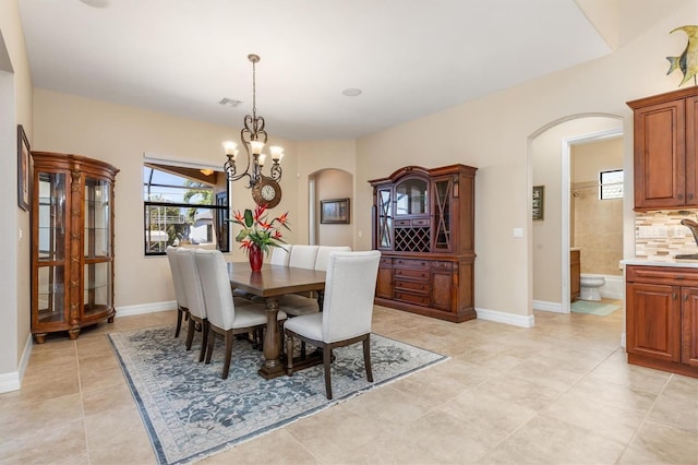 tiled dining room featuring a notable chandelier