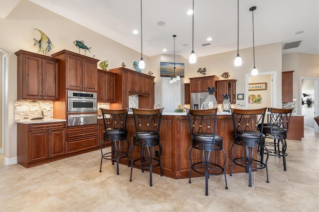 kitchen with a large island, tasteful backsplash, decorative light fixtures, a breakfast bar, and appliances with stainless steel finishes