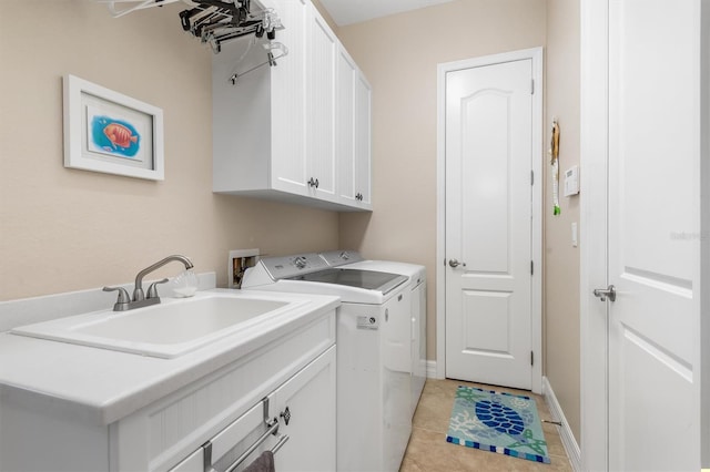 laundry area with washer and clothes dryer, sink, light tile patterned floors, and cabinets