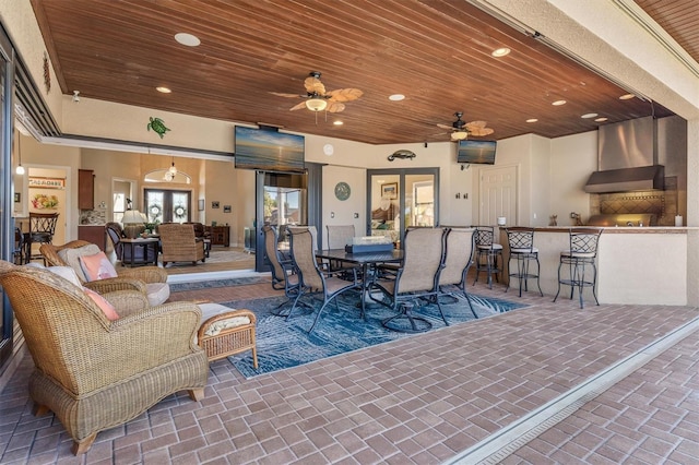 view of patio / terrace with ceiling fan, a bar, and an outdoor living space