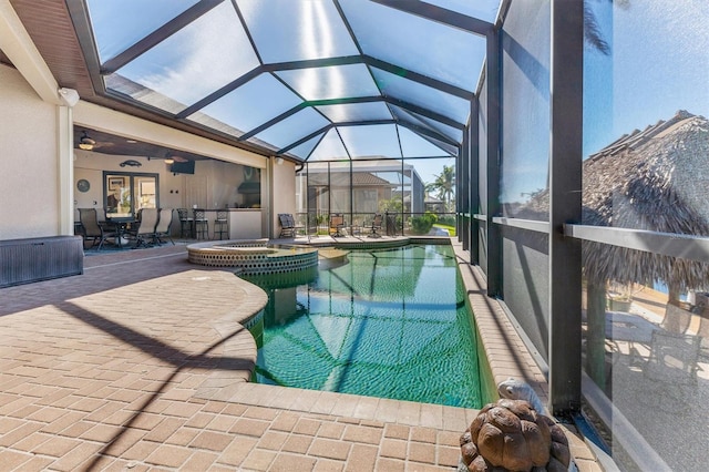 view of swimming pool with an in ground hot tub, a lanai, ceiling fan, and a patio area