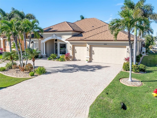 view of front of home with a garage and a front lawn