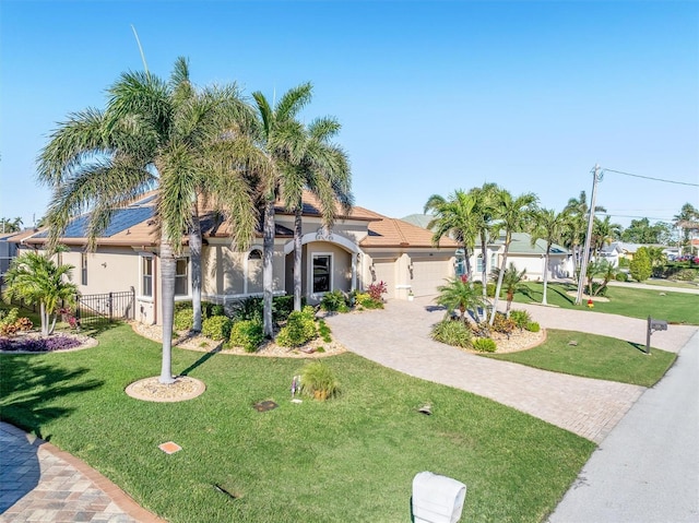 mediterranean / spanish-style home with a front yard and a garage