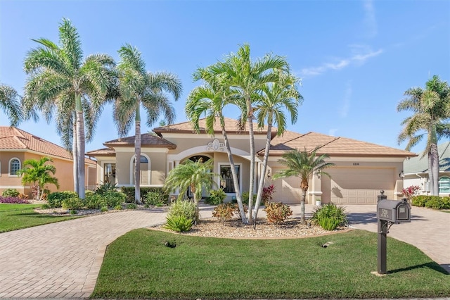 mediterranean / spanish-style home featuring a front lawn and a garage