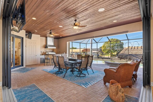 view of patio with area for grilling, ceiling fan, and a lanai