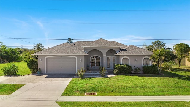 view of front of property featuring french doors, a front lawn, and a garage