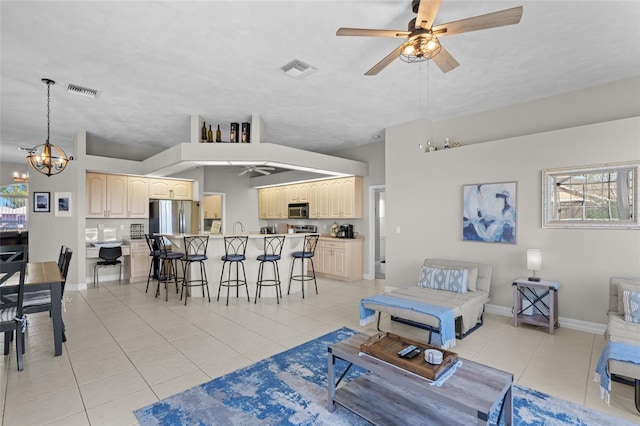 228 Nicholas Pkwy E, Cape Coral, FL 33990 - living area featuring visible vents, baseboards, ceiling fan with notable chandelier, and light tile patterned floors
