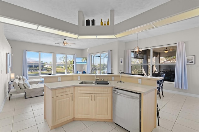 228 Nicholas Pkwy E, Cape Coral, FL 33990 - kitchen with stainless steel dishwasher, light brown cabinetry, open floor plan, light countertops, and a sink
