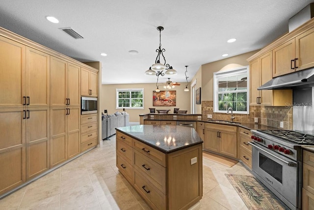 kitchen with stainless steel appliances, sink, decorative light fixtures, kitchen peninsula, and decorative backsplash