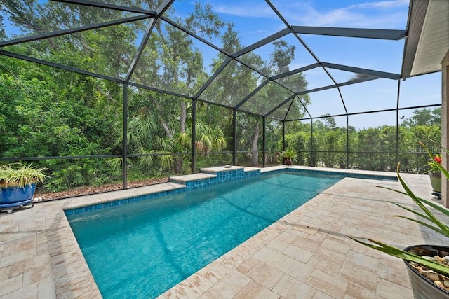 view of pool with glass enclosure and a patio