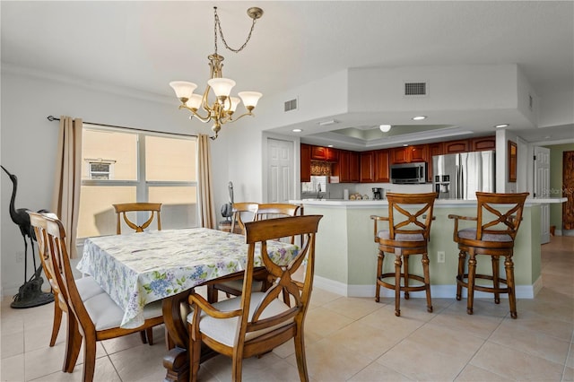 dining room featuring a raised ceiling, light tile patterned floors, and an inviting chandelier