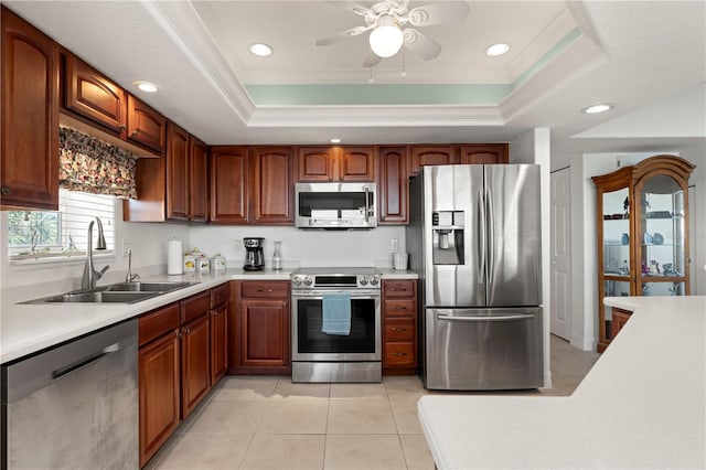 kitchen featuring appliances with stainless steel finishes, a raised ceiling, crown molding, and sink