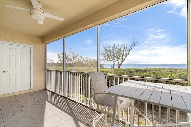 sunroom / solarium featuring a water view and ceiling fan