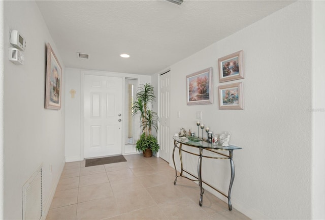 foyer with light tile patterned floors and a textured ceiling