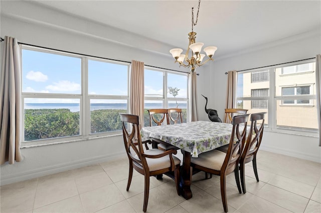 dining room with light tile patterned floors, a water view, a wealth of natural light, and a notable chandelier