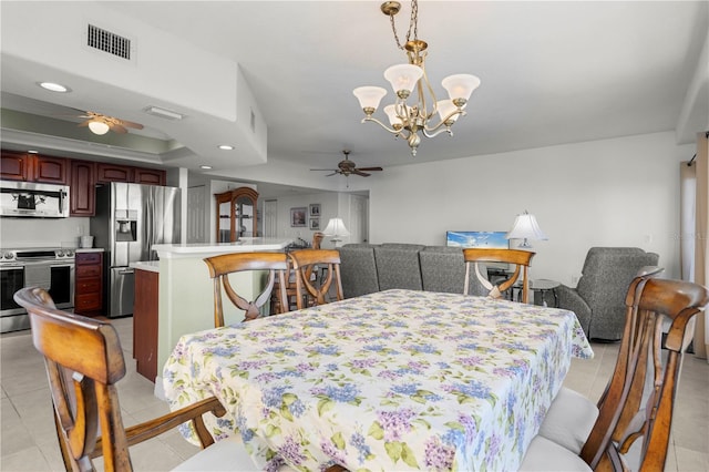 tiled dining space featuring ceiling fan with notable chandelier