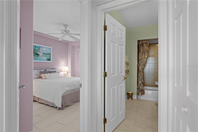 bedroom with ceiling fan, light tile patterned flooring, and ensuite bathroom