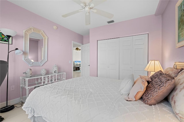 tiled bedroom with ceiling fan and a closet