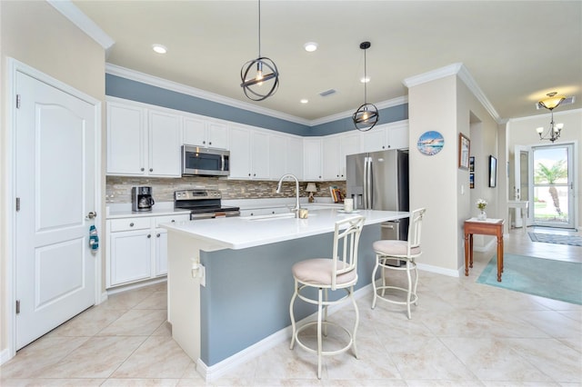 kitchen with white cabinetry, pendant lighting, a center island with sink, light tile patterned flooring, and appliances with stainless steel finishes