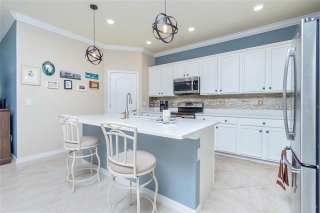 kitchen with white cabinetry, an island with sink, decorative light fixtures, and appliances with stainless steel finishes