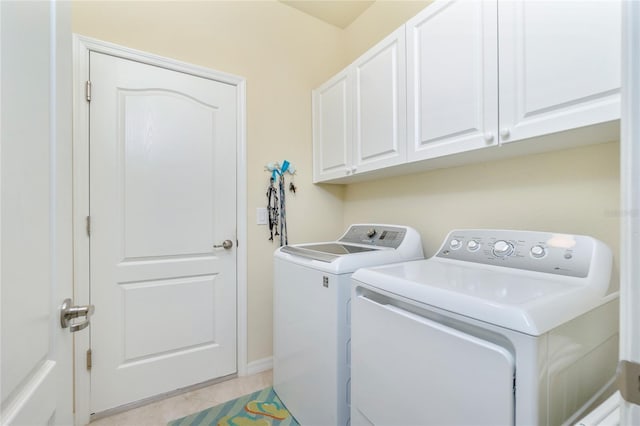 washroom featuring cabinets, washer and dryer, and light tile patterned flooring