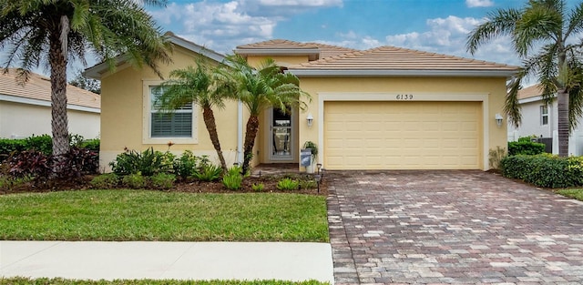 mediterranean / spanish-style home featuring a garage and a front lawn