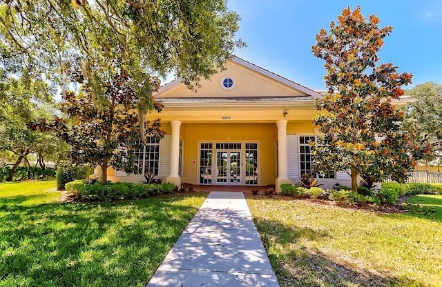 doorway to property with a lawn and french doors